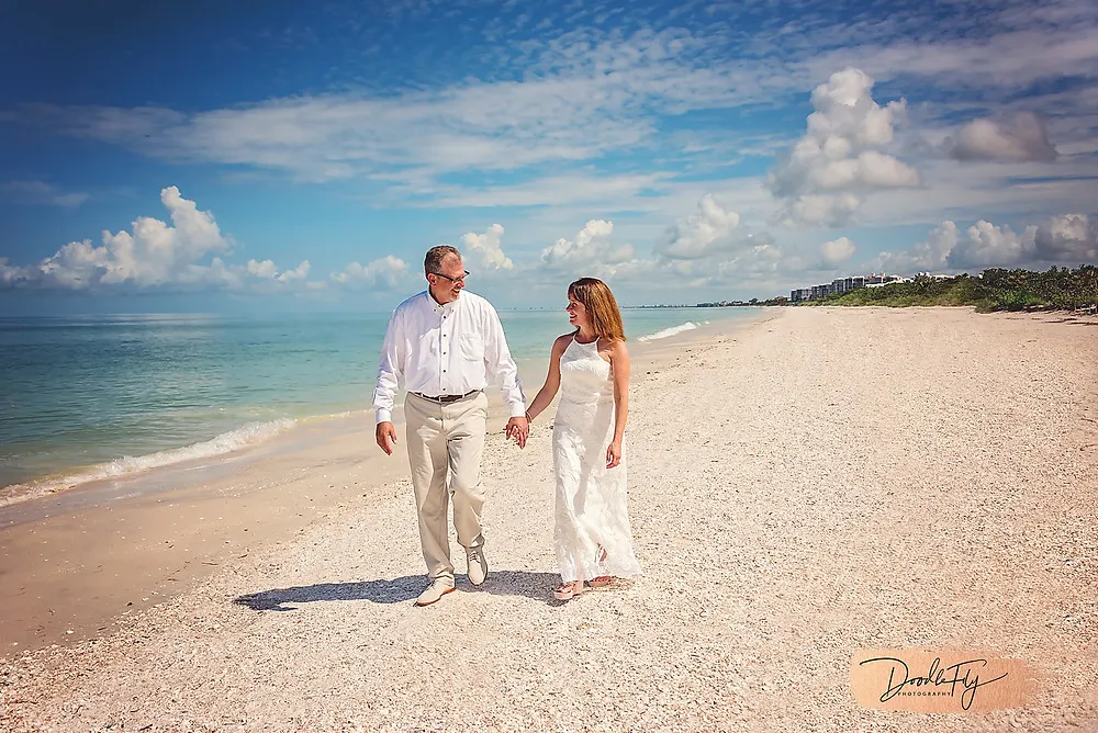 Bride  and Groom walk on the beach, barefoot Beach, Naples Florida photo by Doodle Fly Photography