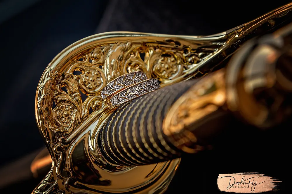 Doodle FLy Photography wedding photo of Grooms Navy Saber Sword and Wedding Rings Detail  at The Luminary Hotel and Burroughs Home Venue in Fort Myers Florida