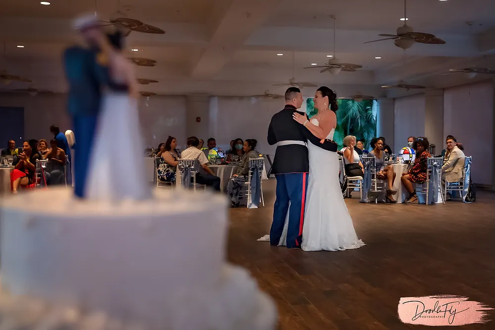 Doodle FLy Photography wedding photo of bride and groom dancing and wedding cake in foreground during first dance at Burroughs Home Venue in Fort Myers Florida
